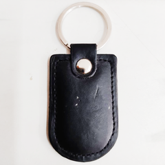 A black leather keychain with a metal ring and a leather strap.