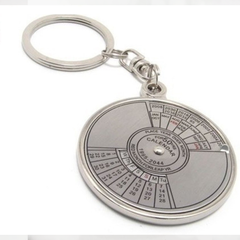 A circular metal keychain with a calendar design, featuring numbers from 1 to 12 and a central rotating dial.