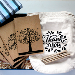 A collection of eco-friendly items including a tote bag, notebooks, and pens, all branded with a design, packaged in a customized keepsake box.