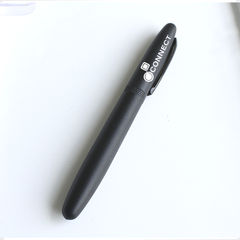 A black executive pen with a fine tip, laying on a white surface.