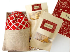 A designer-branded gift box containing a pouch of trail mix and two savory packs of jowar puffs and methi bites.